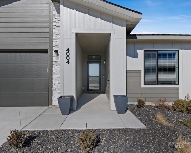 doorway to property with a garage and board and batten siding