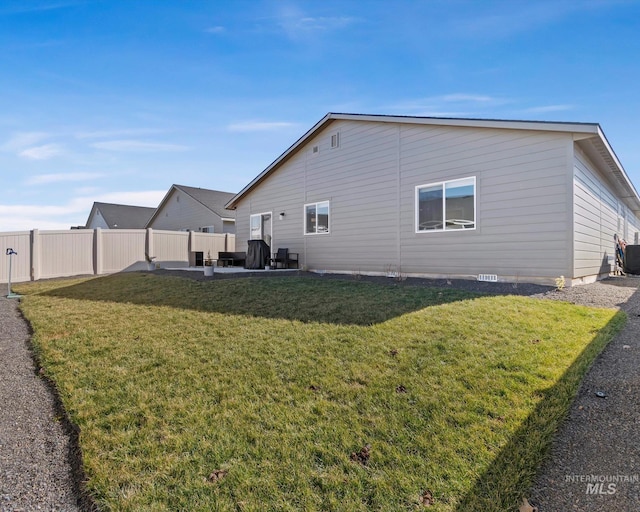 view of home's exterior featuring fence, a patio, and a lawn