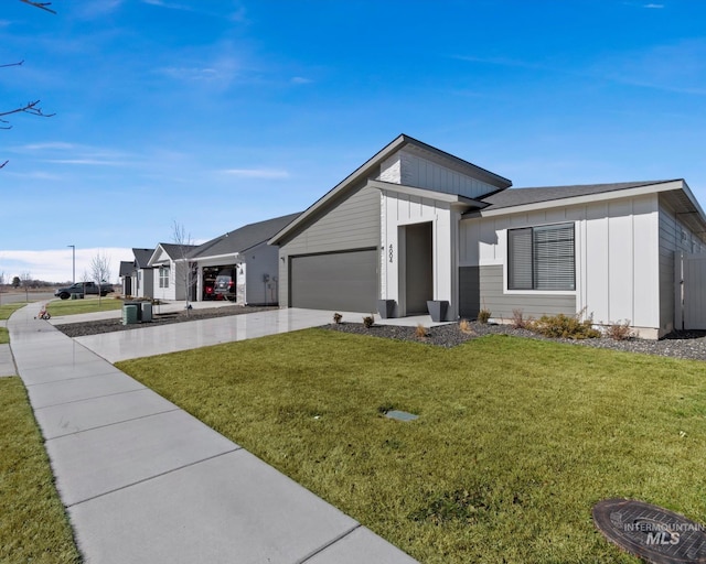 view of front of home with board and batten siding, a front yard, concrete driveway, and an attached garage