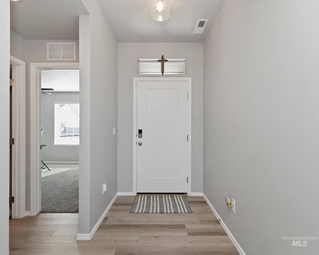 entryway with light wood-type flooring, visible vents, and baseboards