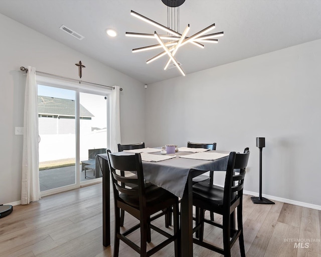 dining space featuring lofted ceiling, visible vents, light wood-style floors, a chandelier, and baseboards