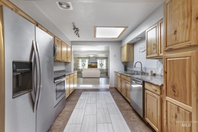 564 Blue Lakes Blvd, Twin Falls, ID 83301 - kitchen featuring appliances with stainless steel finishes, a sink, backsplash, and a skylight