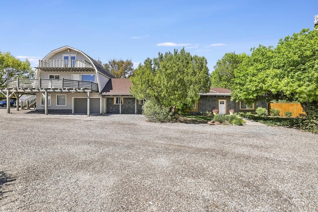 564 Blue Lakes Blvd, Twin Falls, ID 83301 - view of front of home with a gambrel roof, driveway, a garage, a wooden deck, and stairs