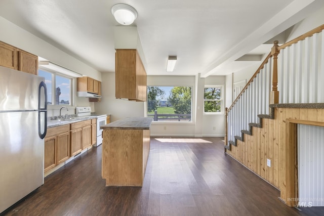 564 Blue Lakes Blvd, Twin Falls, ID 83301 - kitchen with freestanding refrigerator, white range with electric cooktop, dark wood-style floors, under cabinet range hood, and brown cabinets