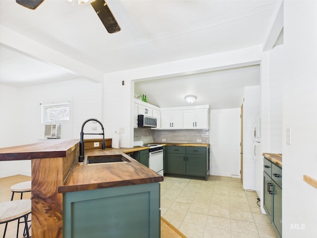 kitchen with a breakfast bar area, a sink, stainless steel microwave, butcher block counters, and white range with electric stovetop
