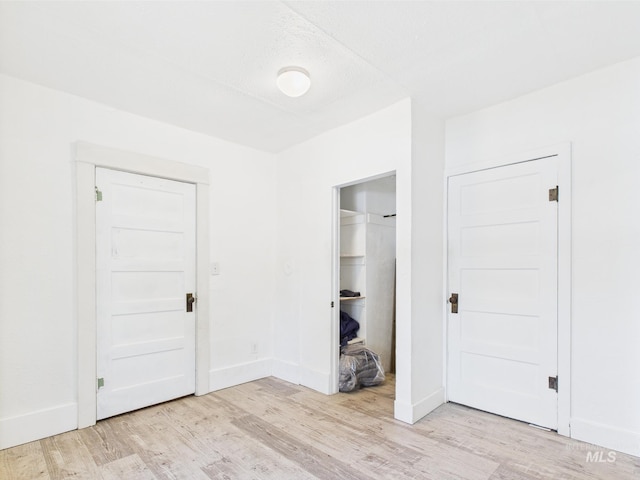 unfurnished bedroom with baseboards and light wood finished floors