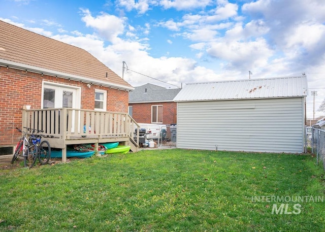 back of house featuring a lawn and a deck