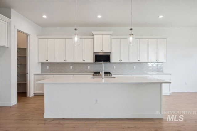 8828 S Waterclover Way, Meridian, ID 83642 - kitchen featuring light countertops, decorative light fixtures, tasteful backsplash, and recessed lighting