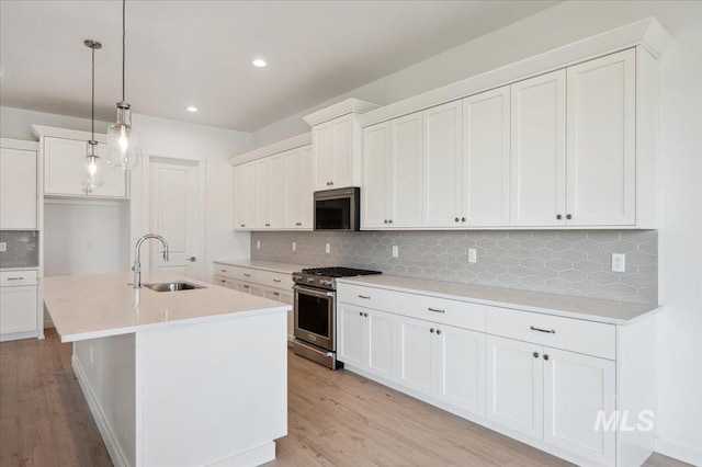 8828 S Waterclover Way, Meridian, ID 83642 - kitchen with a sink, stainless steel stove, tasteful backsplash, light wood-style flooring, and recessed lighting