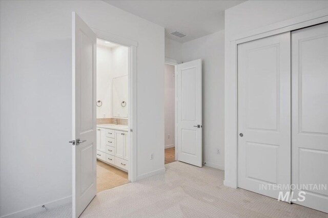 8828 S Waterclover Way, Meridian, ID 83642 - unfurnished bedroom featuring light carpet, a closet, connected bathroom, and baseboards