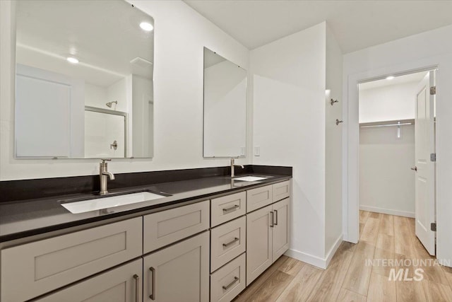 bathroom featuring a shower with door, vanity, and hardwood / wood-style flooring