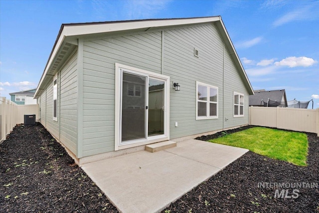 rear view of house with central air condition unit and a patio area