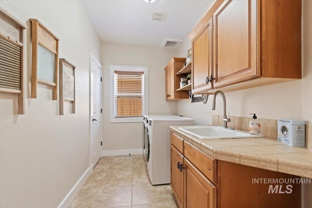 9740 W Shields Ave, Boise, ID 83714 - laundry area featuring washer and clothes dryer, cabinet space, baseboards, and light tile patterned flooring