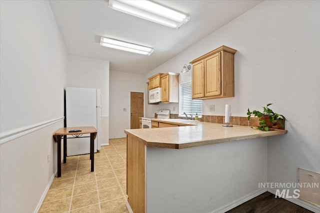 9740 W Shields Ave, Boise, ID 83714 - kitchen featuring white appliances, a peninsula, light countertops, a sink, and baseboards