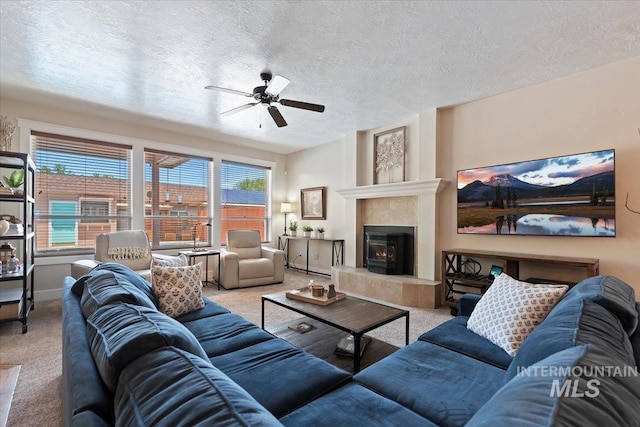 9740 W Shields Ave, Boise, ID 83714 - living area with carpet, a ceiling fan, a tile fireplace, a textured ceiling, and baseboards