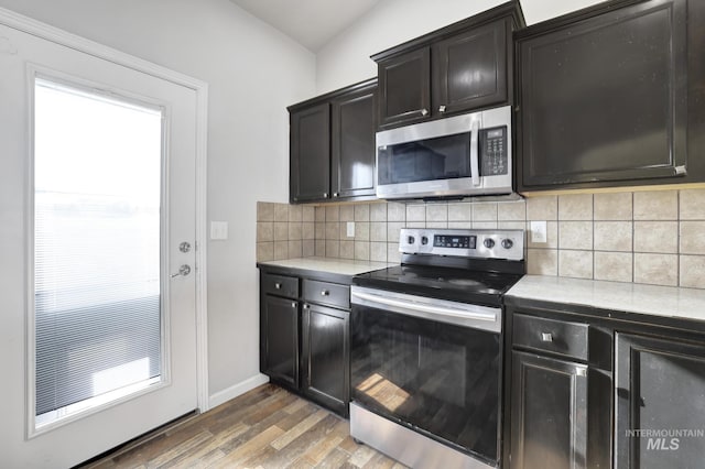 1095 Starlight Loop, Twin Falls, ID 83301 - kitchen featuring appliances with stainless steel finishes, light countertops, light wood-style floors, and backsplash