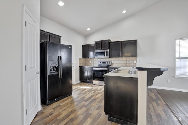 1095 Starlight Loop, Twin Falls, ID 83301 - kitchen with appliances with stainless steel finishes, tasteful backsplash, lofted ceiling, a peninsula, and wood finished floors