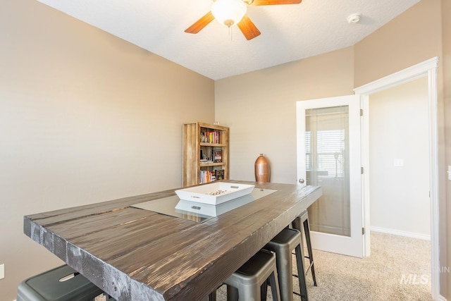 dining area with light colored carpet and ceiling fan