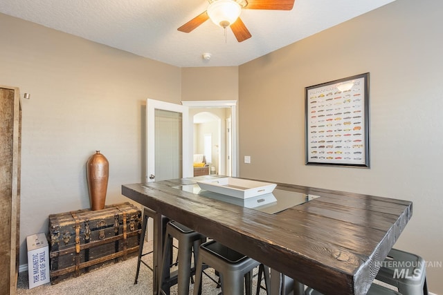 dining room with ceiling fan, carpet flooring, and a textured ceiling