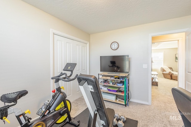 exercise area with carpet and a textured ceiling