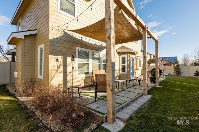 rear view of property featuring a yard and a patio area