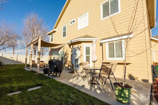 back of house featuring a patio area and a lawn