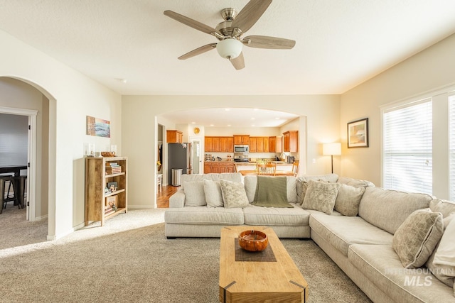 carpeted living room featuring ceiling fan