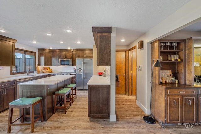 4400 W Pasadena Dr Unit 38, Boise, ID 83705 - kitchen with appliances with stainless steel finishes, a kitchen breakfast bar, light wood-type flooring, recessed lighting, and a kitchen island