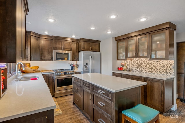 4400 W Pasadena Dr Unit 38, Boise, ID 83705 - kitchen with appliances with stainless steel finishes, a sink, dark brown cabinets, backsplash, and light countertops