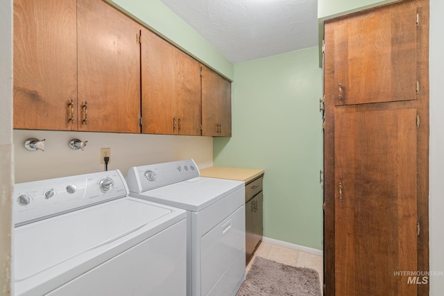 4400 W Pasadena Dr Unit 38, Boise, ID 83705 - laundry room with cabinet space, washer and clothes dryer, light tile patterned floors, baseboards, and a textured ceiling