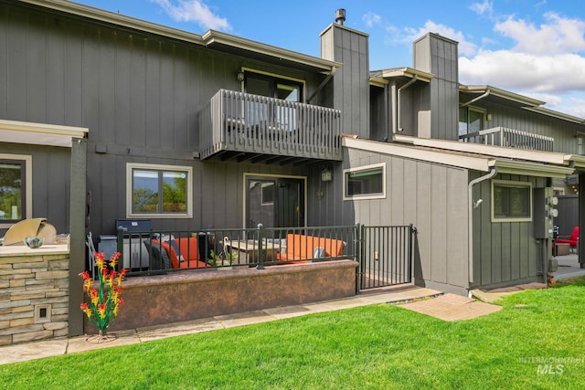 4400 W Pasadena Dr Unit 38, Boise, ID 83705 - rear view of house with a balcony, a chimney, and a lawn