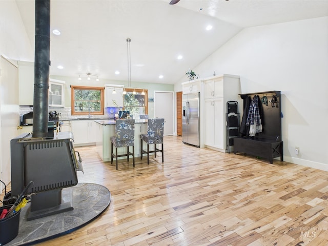 9 Pond Overlook, Idaho City, ID 83631 - interior space with light wood-style flooring, a sink, white cabinetry, stainless steel fridge, and a wood stove