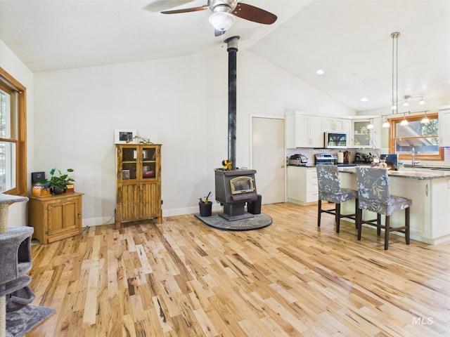 9 Pond Overlook, Idaho City, ID 83631 - living room featuring a ceiling fan, a healthy amount of sunlight, a wood stove, and light wood finished floors