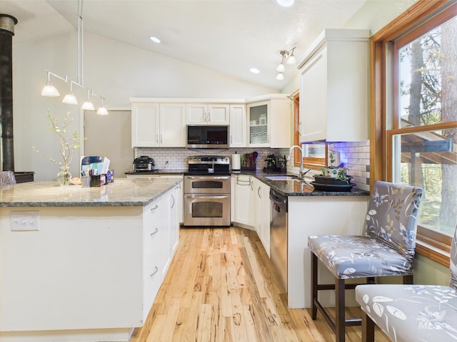 9 Pond Overlook, Idaho City, ID 83631 - kitchen with a sink, appliances with stainless steel finishes, vaulted ceiling, white cabinets, and light wood-style floors