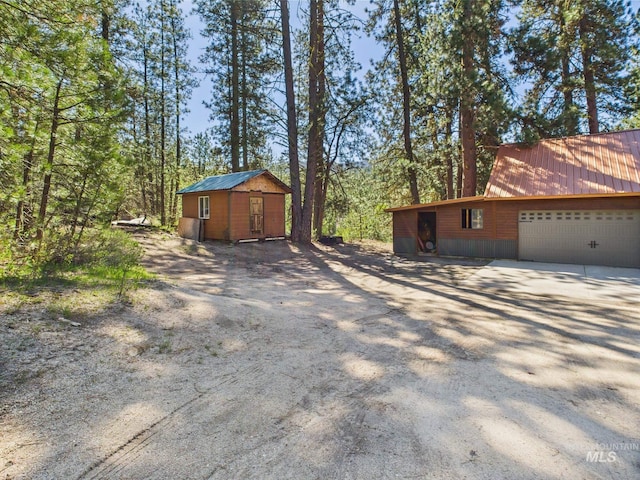 9 Pond Overlook, Idaho City, ID 83631 - view of side of home with dirt driveway, metal roof, and an outbuilding