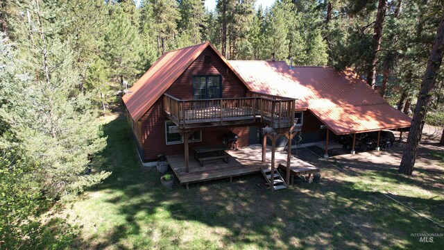 9 Pond Overlook, Idaho City, ID 83631 - back of house with a wooded view, a wooden deck, a lawn, and metal roof