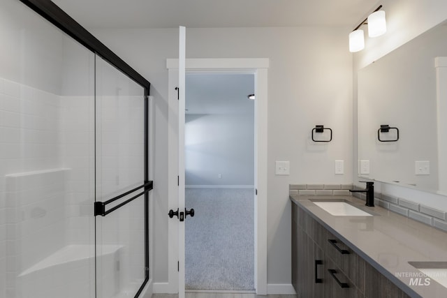 2431 W Opalite Dr, Kuna, ID 83634 - full bathroom with baseboards, double vanity, a sink, and a stall shower