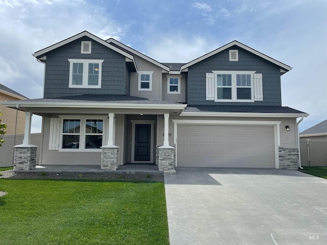 craftsman house with covered porch, a garage, fence, a front lawn, and driveway