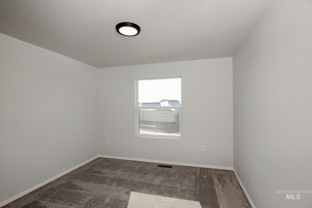 unfurnished room with dark carpet