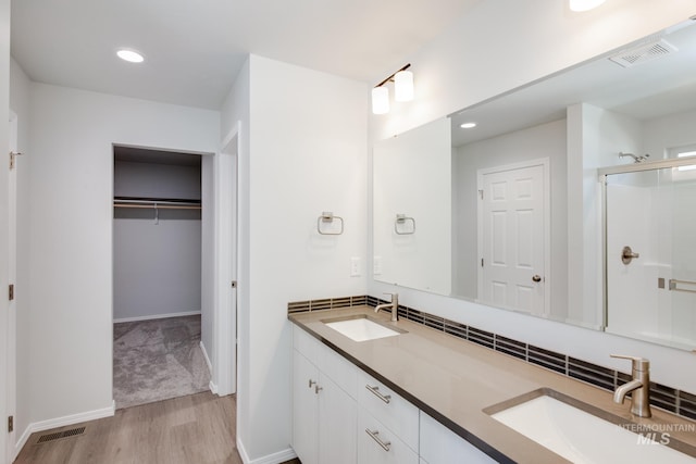 bathroom featuring walk in shower, vanity, and wood-type flooring