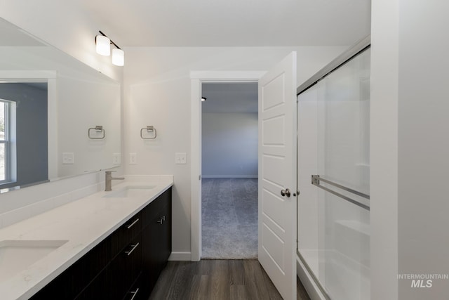 bathroom featuring hardwood / wood-style flooring, vanity, and an enclosed shower