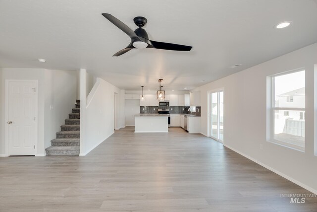 unfurnished living room featuring light hardwood / wood-style floors and ceiling fan