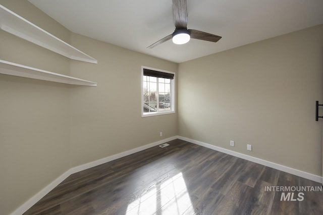 unfurnished room featuring ceiling fan, visible vents, baseboards, and dark wood finished floors