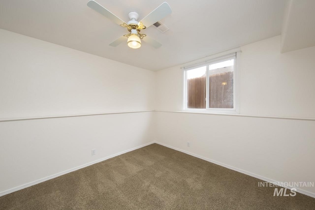 carpeted spare room featuring baseboards, visible vents, and a ceiling fan