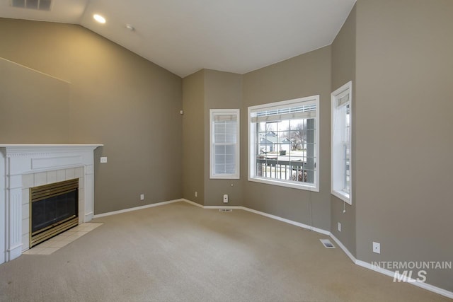 unfurnished living room featuring lofted ceiling, carpet floors, a fireplace, visible vents, and baseboards