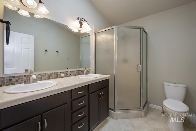 full bathroom featuring toilet, a stall shower, backsplash, and a sink