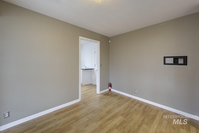 spare room with light wood finished floors and baseboards