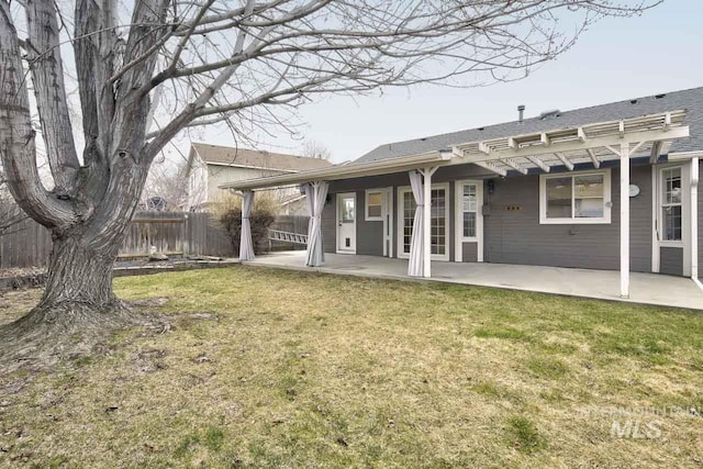 rear view of house featuring a pergola, fence, a lawn, and a patio