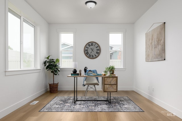 office space featuring visible vents, baseboards, and wood finished floors