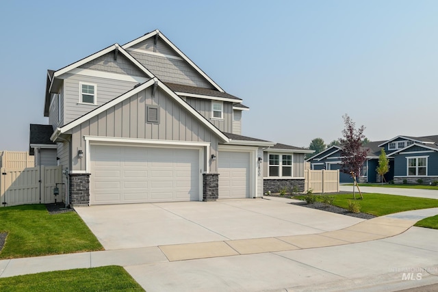 craftsman-style home featuring driveway, an attached garage, a gate, fence, and a front yard